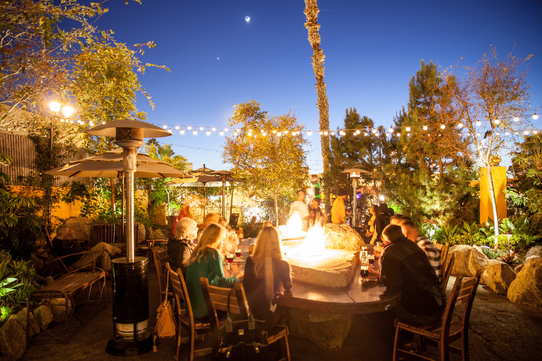 Picture of Stone Brewing Oceanside Tap Room patio in the evening with people sitting around firepit
